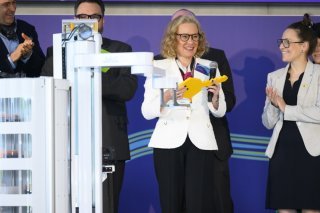 Un robot donne une clé symbolique à Belén Garijo, CEO du groupe Merck (à gauche) et à Séverine Evequoz (à droite), présidente du Grand Conseil vaudois.